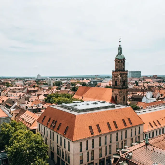 Stadtansicht von Erlangen mit roten Dächern und einem markanten Kirchturm. Standort von SDLK Engineering GmbH